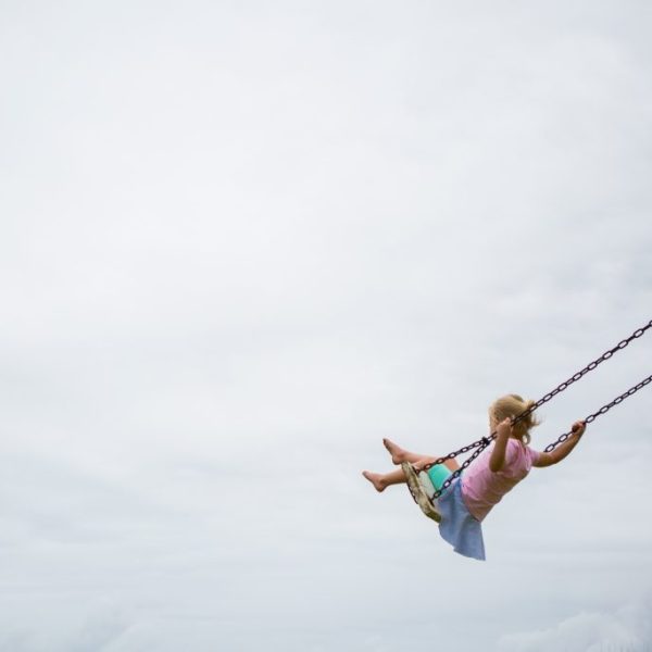 Little girl on a wooden swing